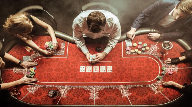 Conceito de cassino, jogos de azar online, tecnologia e pessoas - close-up  do jogador de pôquer com cartas de jogar
